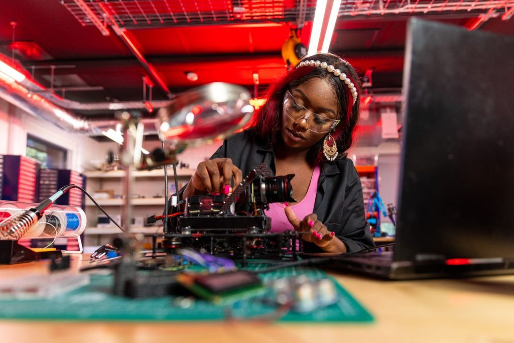 Crafting Captivating Headlines: Your awesome post title goes here Technical woman expertly repairing electronic device in bright workshop setting.